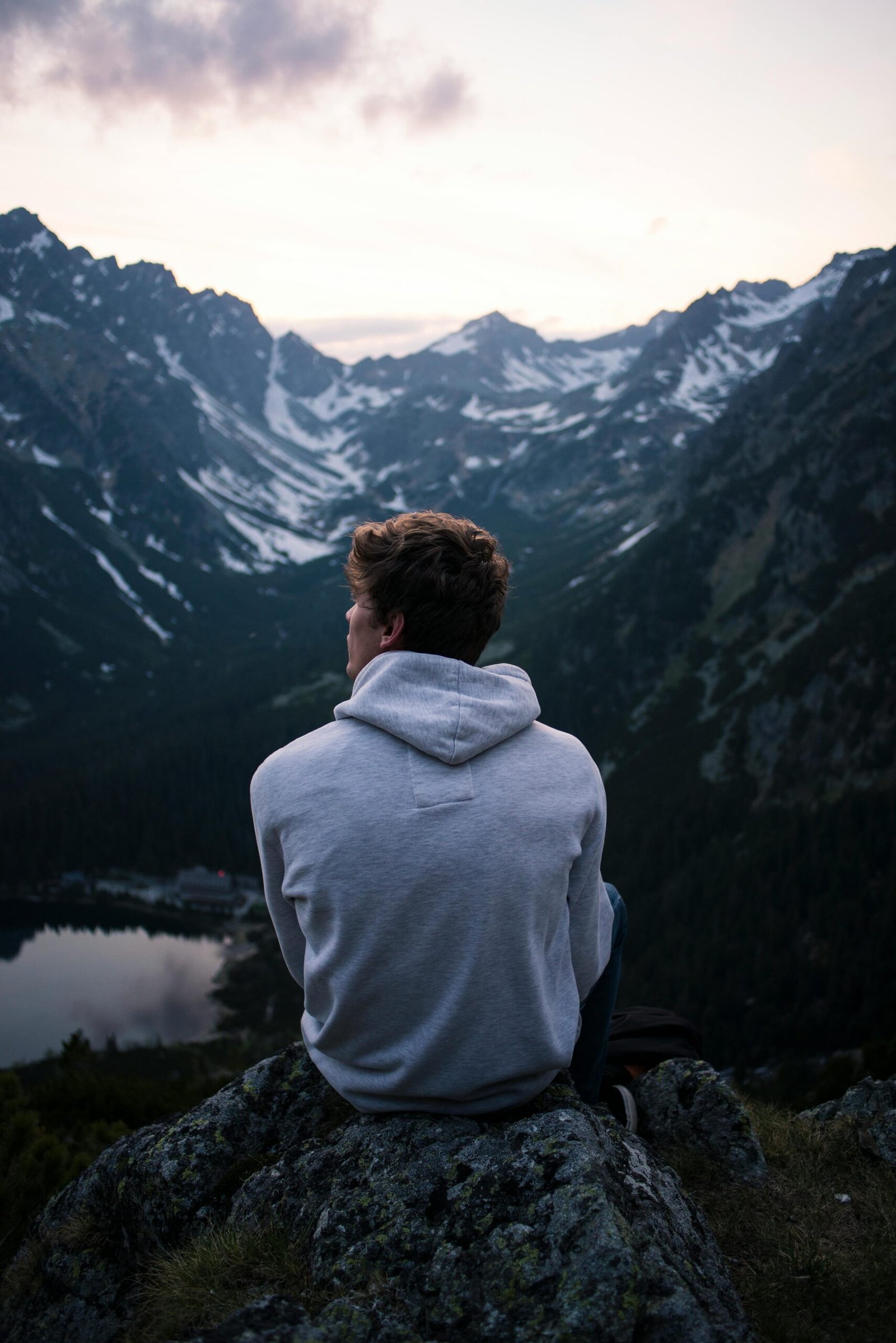 A person enjoying a serene mountain view at twilight, embracing solitude and adventure.